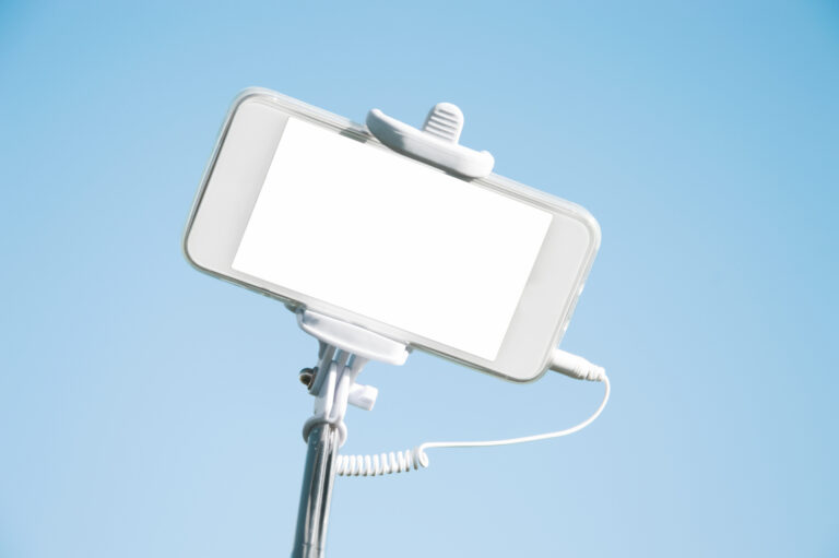 How to take great selfies; smart phone with white blank screen with tripod